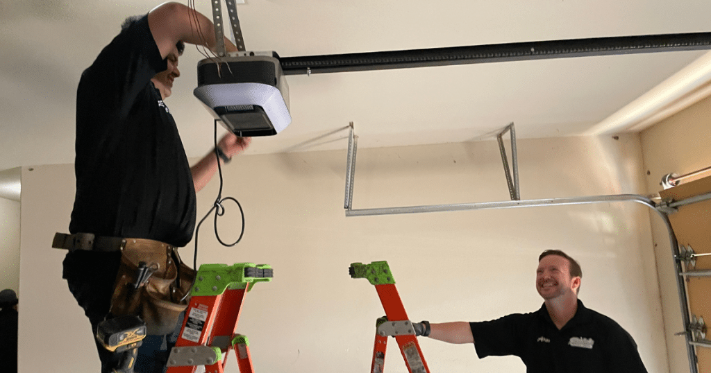Technicians install a new garage door opener.